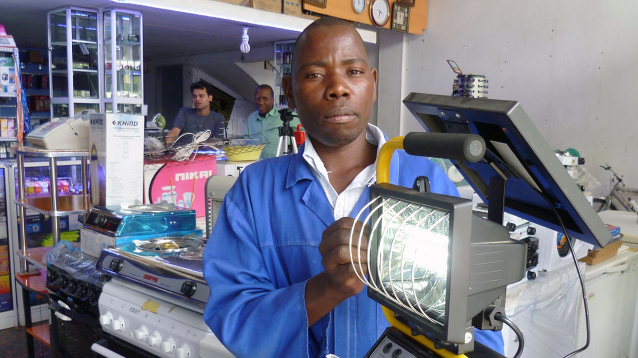 A workshop technician displaying a solar powered lamp